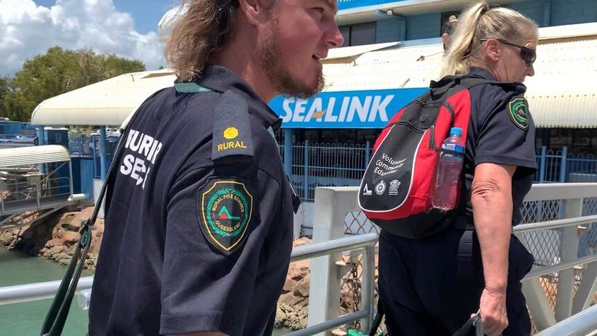 A male and female boarding a ferry in North Queensland wearing Rural Fire Service uniforms.
