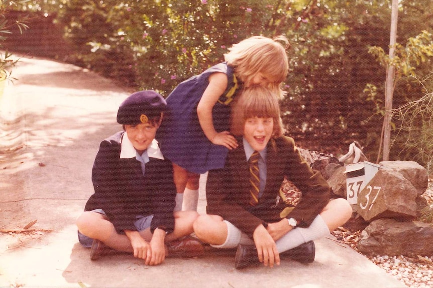 Tim Nicholls sits on ground in Melbourne in 1976 with his two sisters Sandra (left) and Sophie (right).