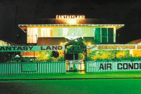 A historic photo of the exterior of a two-storey building at night with the words Fantasy Land in lights on the roof.