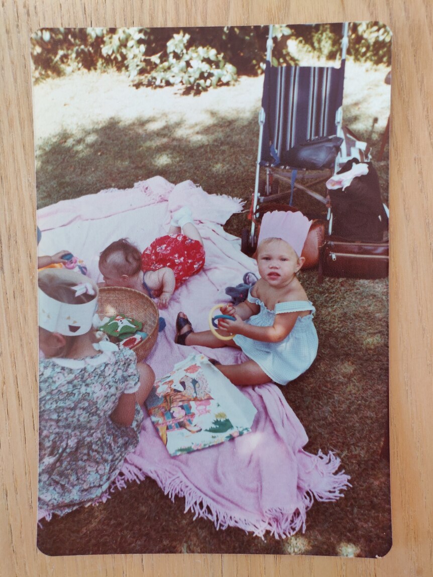 Old family photo of Dara Read as a toddler, wearing a blue dress and pink party hat