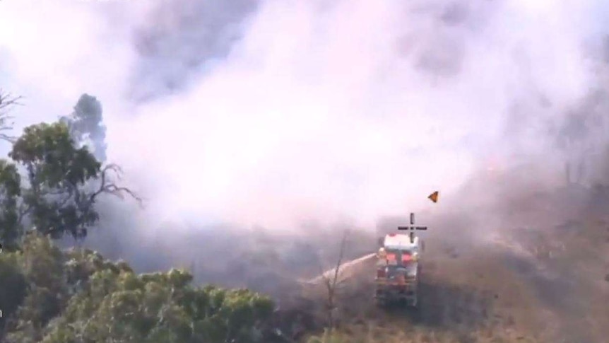 aerial vision of firetruck spraying at a bushfire