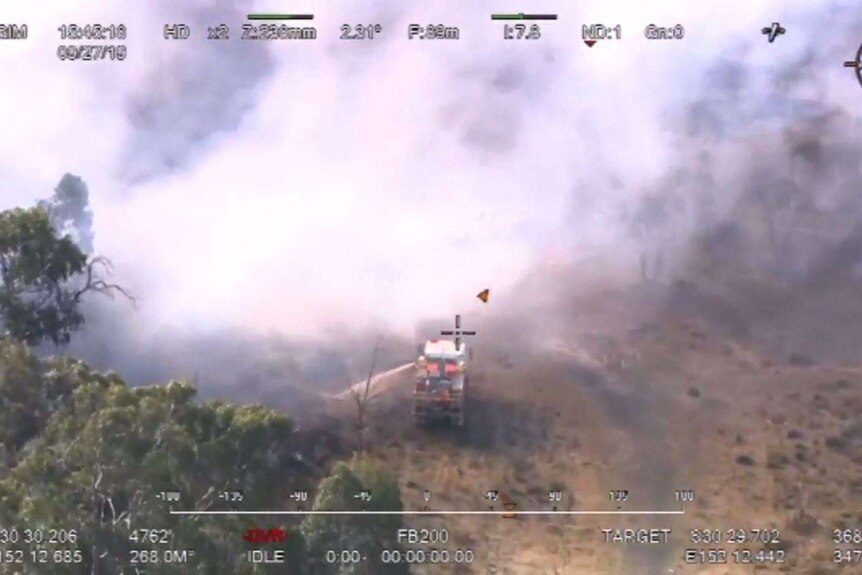 aerial vision of firetruck spraying at a bushfire