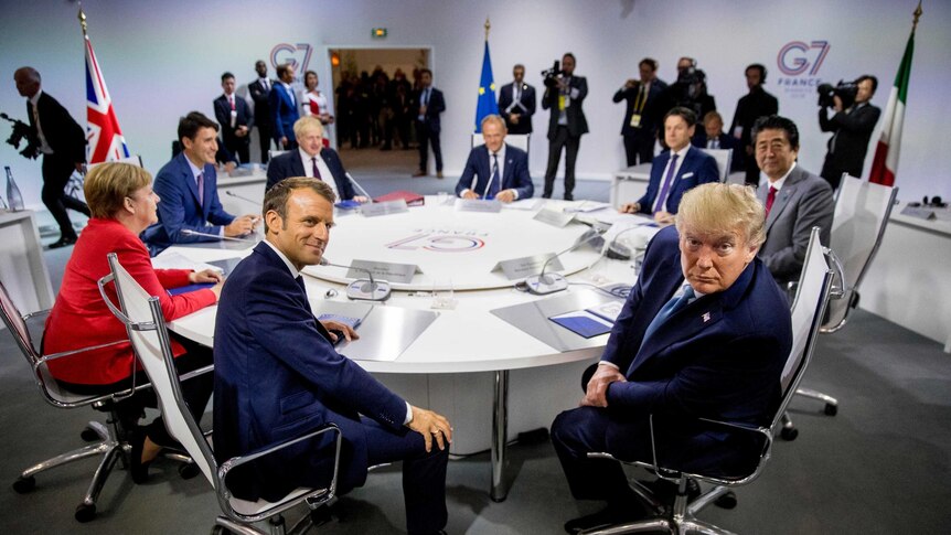 G7 leaders meet around a round table. Emmanuel Macron and Donald Trump are at the centre of the image.