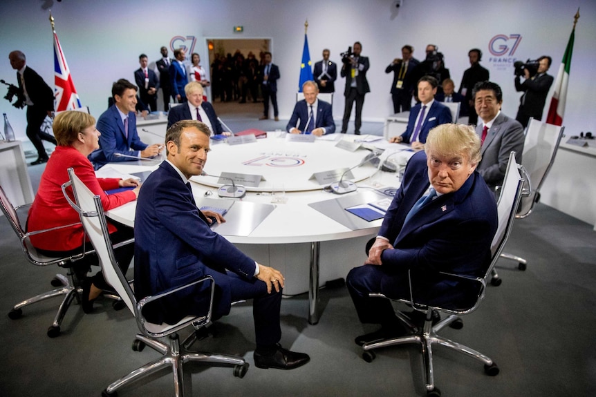 G7 leaders meet around a round table. Emmanuel Macron and Donald Trump are at the centre of the image.