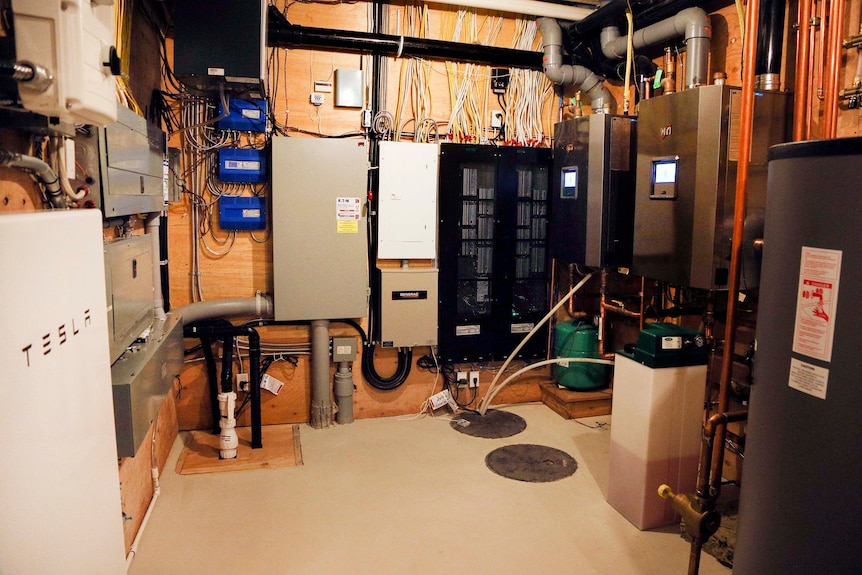 A basement room with many cables and wall-mounted boxes coordinating the home's energy