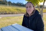 Stacey Lodge sits outside at a park bench.