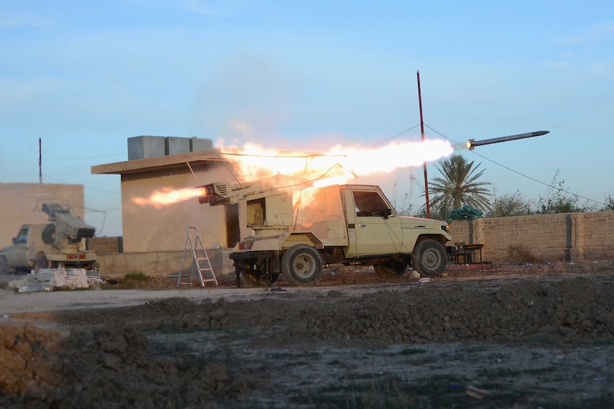 Shiite fighters fire a rocket launcher during clashes with Islamic State militants