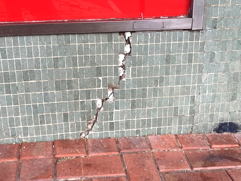 Una grieta en los azulejos verdes del exterior de la tienda.