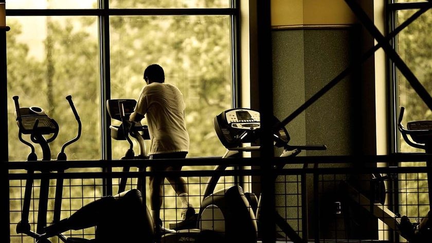 Man (unidentifiable) working out on a step machine in a gym. Good gym, exercise generic.