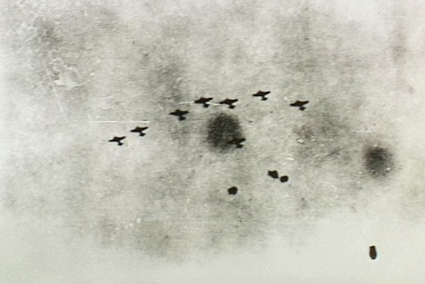 A grainy photo shows eight Japanese planes flying overhead.