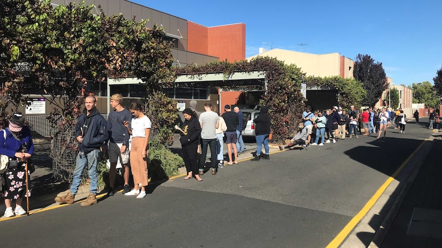 People lining up on a footpath