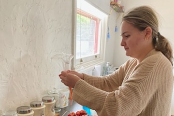 A young woman with blonde hair mixing cake batter in a kitchen