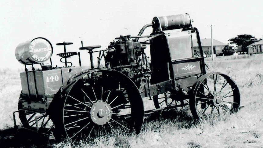 A black and white photo of an old tractor in a field.