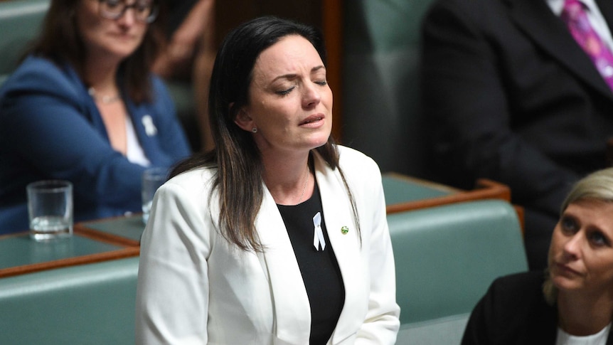 Emma Husar closes her eyes in Parliament as she speaks about her experience with domestic violence