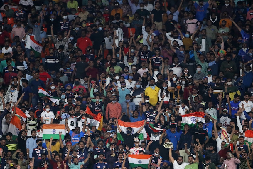 India fans hold India flags in the stands