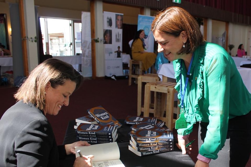 Kirstin Ferguson signs copy of Women Kind for Queensland Opposition leader Deb Frecklington