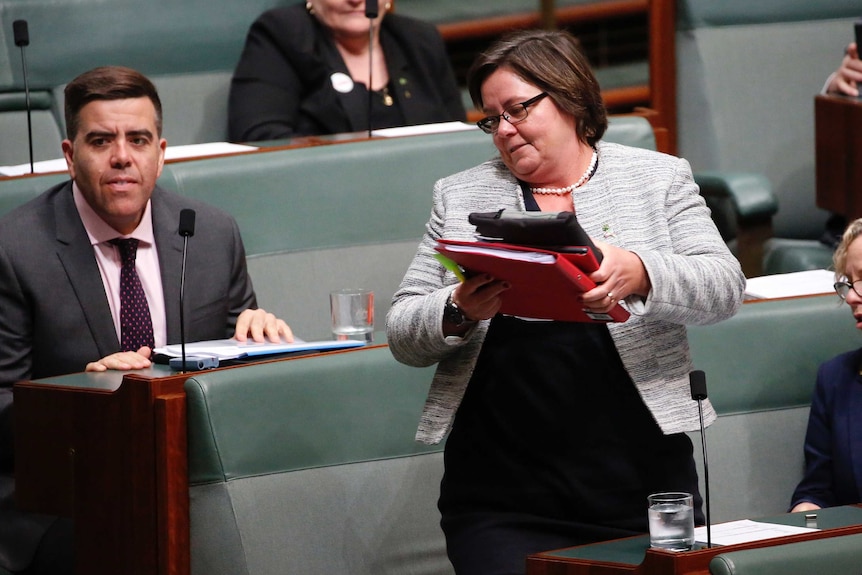 WA Labor MP Madeleine King leaves Question Time. She's wearing a grey jacket and holding a stack of folders.