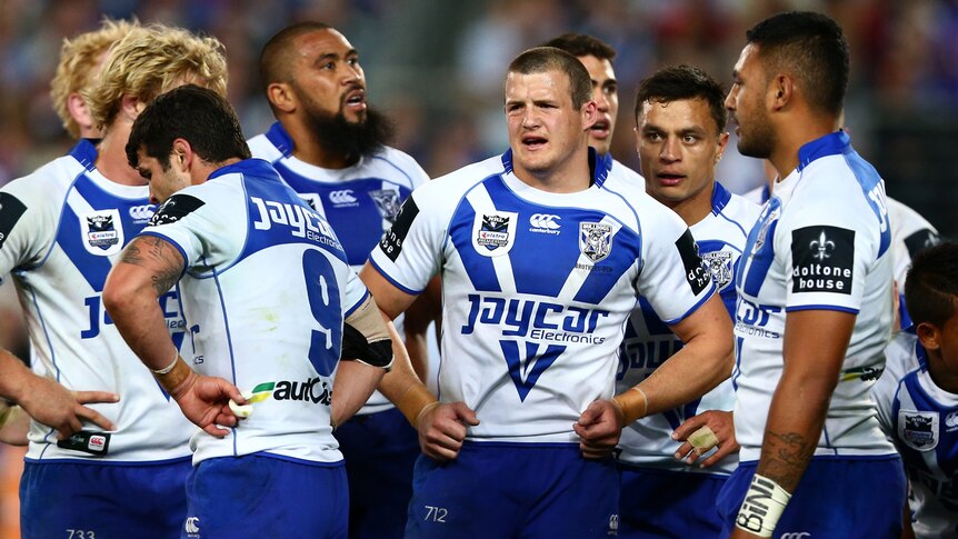 Bulldogs players watch the grand final slip away against the Storm.