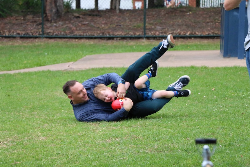 Tim Wolnizer plays football with his three-year-old Micah