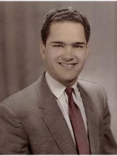 An old fashioned photo portrait of a young man wearing a suit.