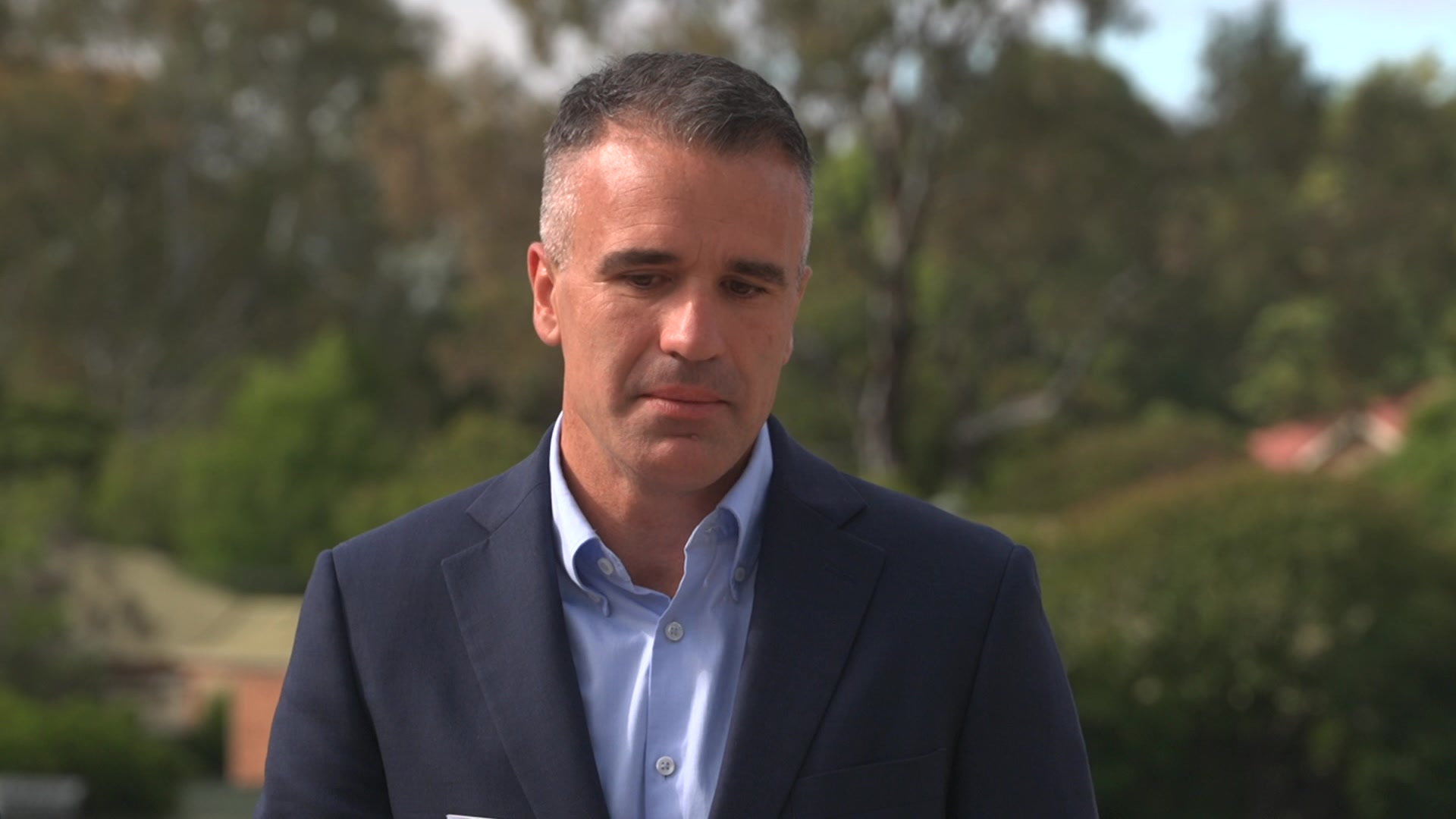 Peter Malinauskas viste traje y mira hacia abajo