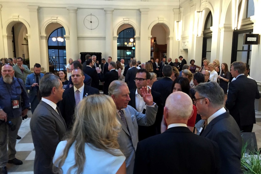 Prince Charles is surrounded by people in the foyer of Perth's State Buildings.