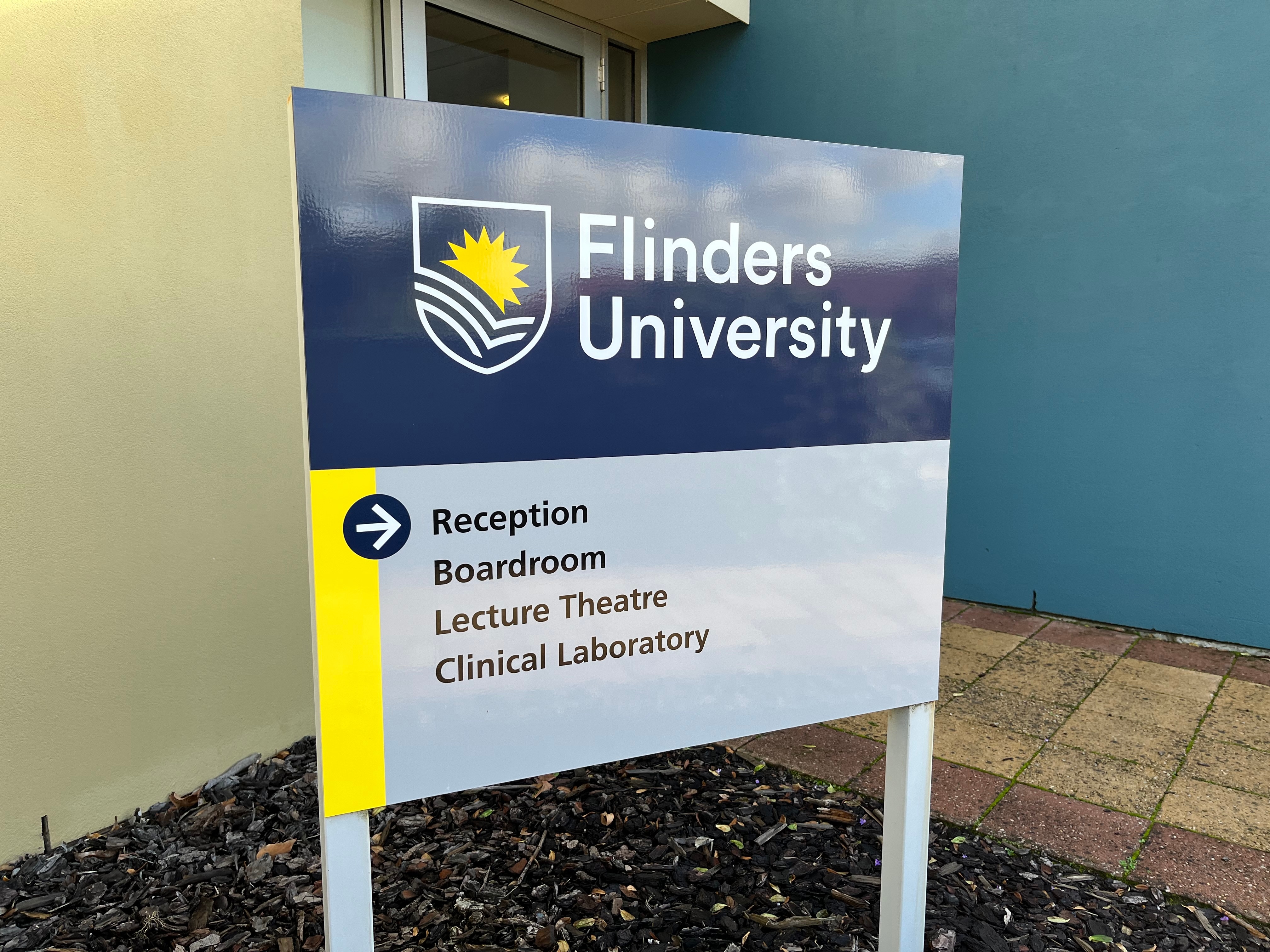 A sign at a university pointing towards the reception, boardroom, lecture theatre and laboratory.