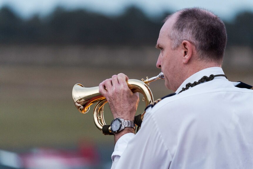 A man plays a bugle at an airport