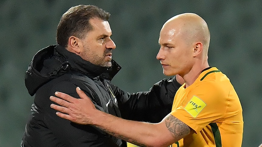 Socceroos coach Ange Postecoglou shakes hands with player Aaron Mooy after a game.