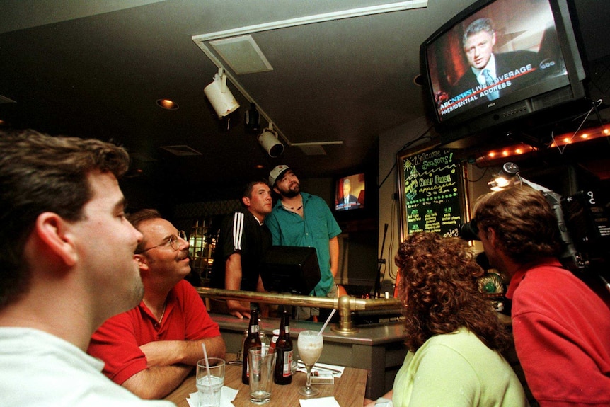 Bar patrons watch President Clinton deliver his speech to the nation late August 17, 1998.