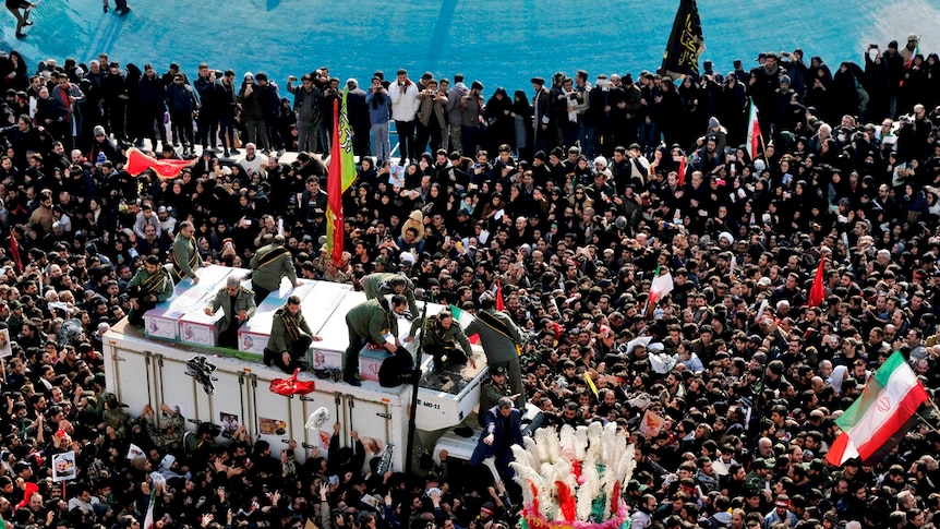 Thousands gather surrounding a truck containing the body of Qassem Soleimani.