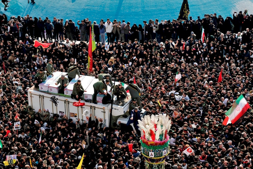 Thousands gather surrounding a truck containing the body of Qassem Soleimani.