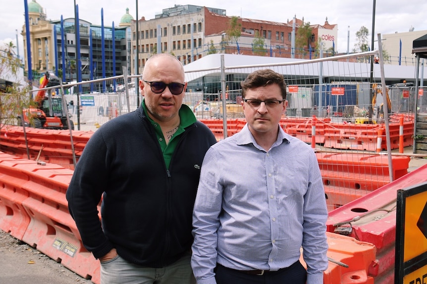 Cafe owner Pierrick Boyer and podiatrist Jesse Hibbs standing on the street, construction works behind them