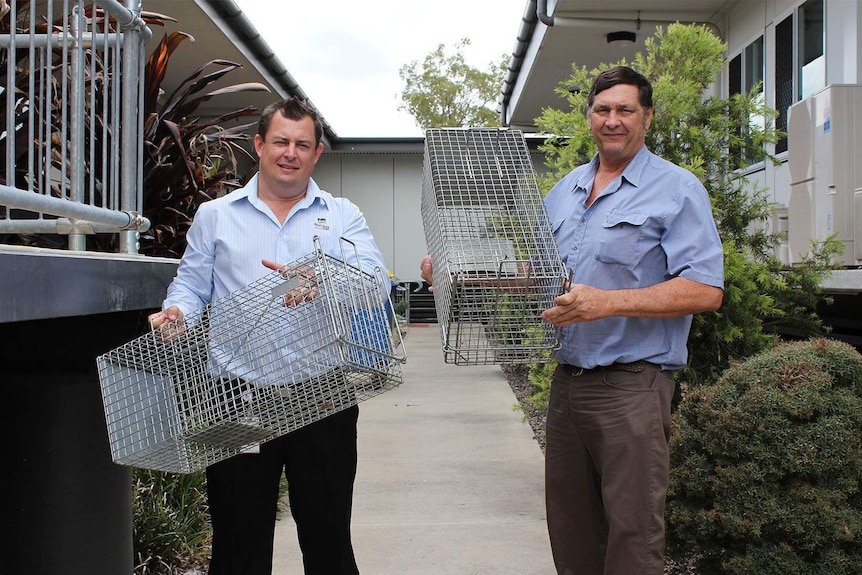 (LtoR) Banana Shire Council's director of services John McDougall and Mayor Nev Ferrier hold up cat traps for residents.