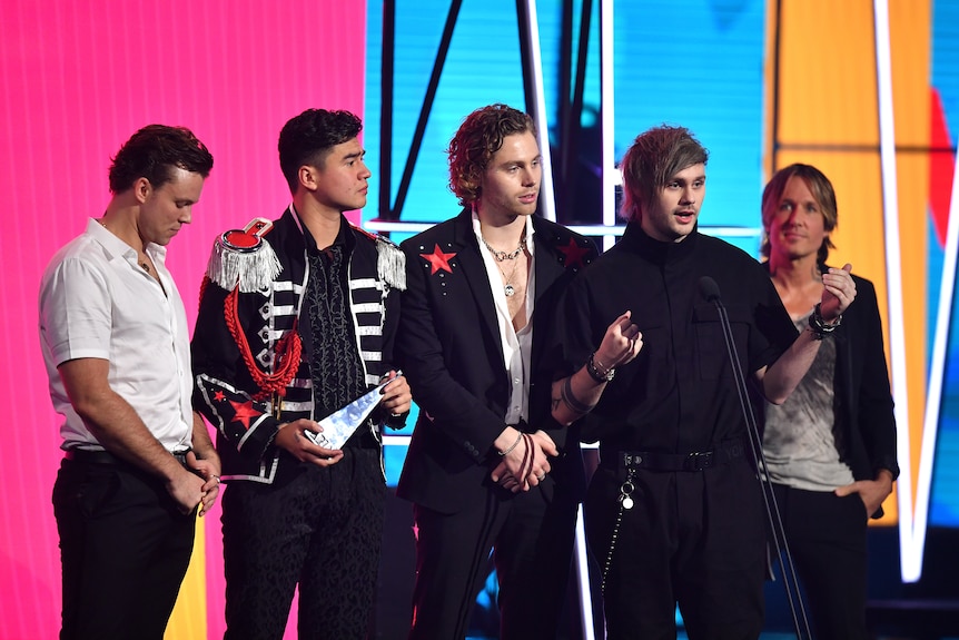 5 young dudes accepting an award.