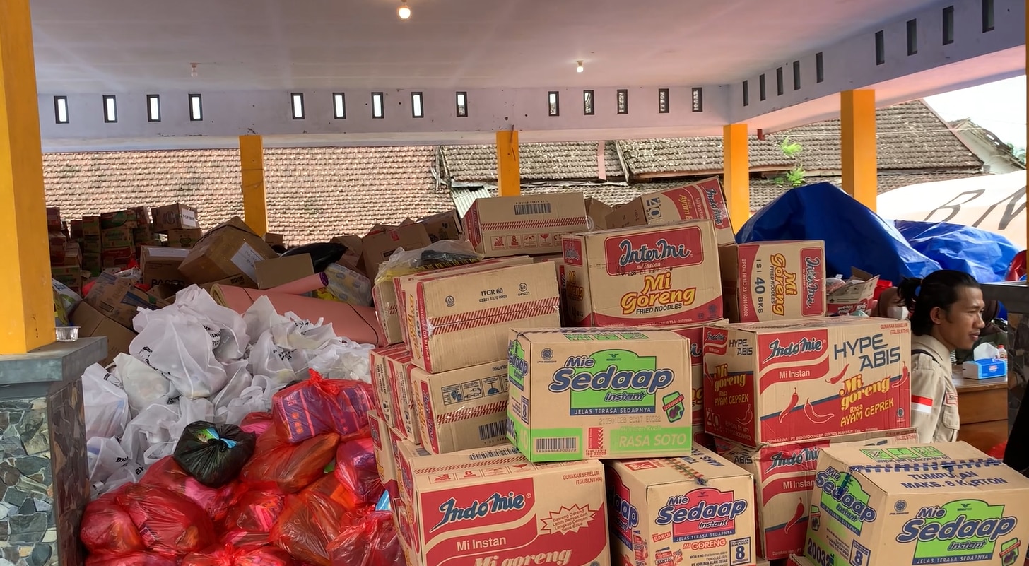Boxes of instant noodles piling up next to plastic bags of staple foods for Semeru victim in Indonesia, December 2021.