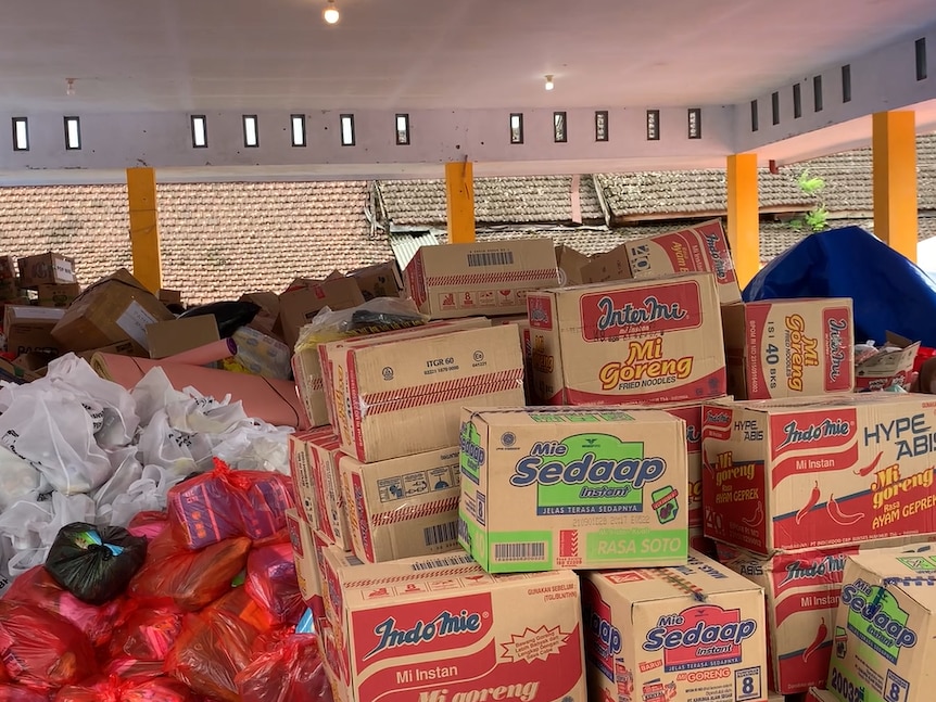 Boxes of instant noodles piling up next to plastic bags of staple foods for Semeru victim in Indonesia, December 2021.