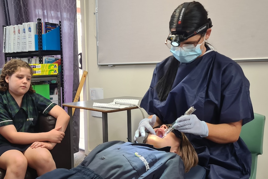 un dentista examina los dientes de un niño