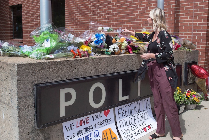 Flowers are placed outside the police station in Fredericton.