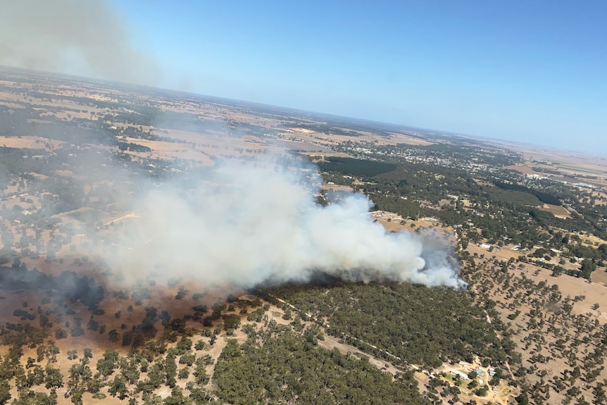 Aerial shot of large smoke plumes from a fire burning through scrubland