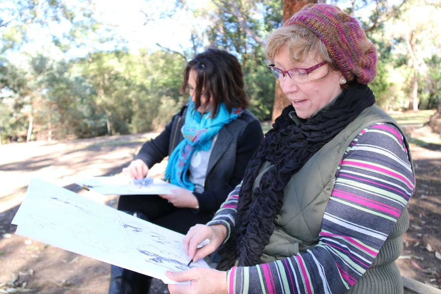 Two women sketch eucalypts at the National Botanic Gardens open day.