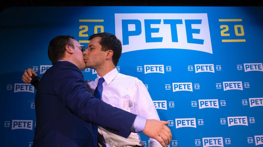 Democratic presidential candidate Pete Buttigieg (right) kisses his husband Chasten Glezman at a campaign event.
