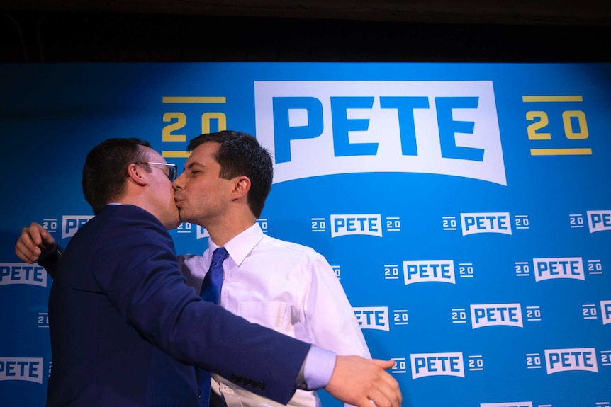 Democratic presidential candidate Pete Buttigieg (right) kisses his husband Chasten Glezman at a campaign event.