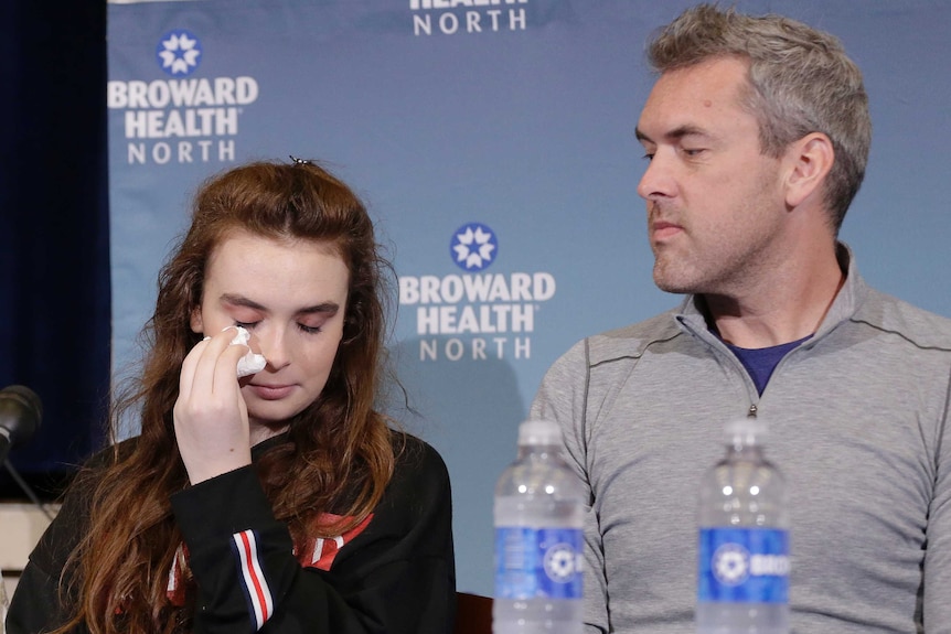 Maddy Wilford wipes a tear from her eye as her father watches on.