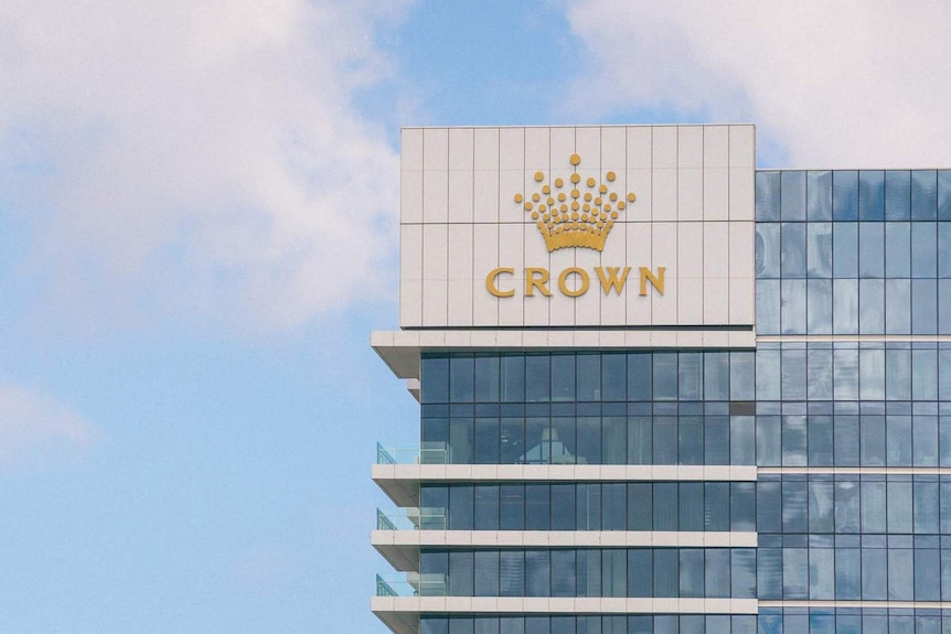 The top floors of one of Crown Perth's hotel towers set against a slightly cloudy blue sky .