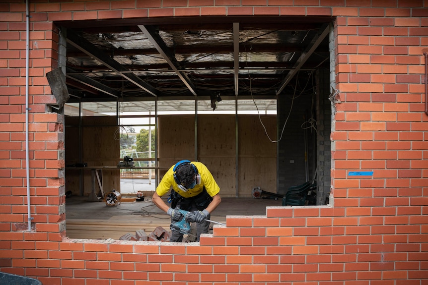 A young man building a house.