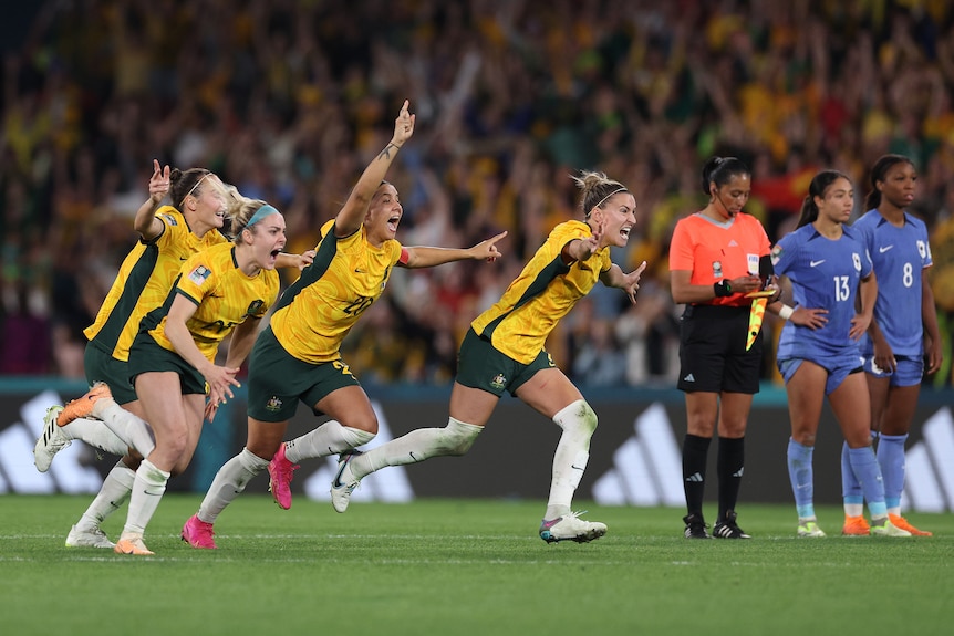 Australia players run to celebrate after winning a Women's WOrld Cup quarterfinal against France.