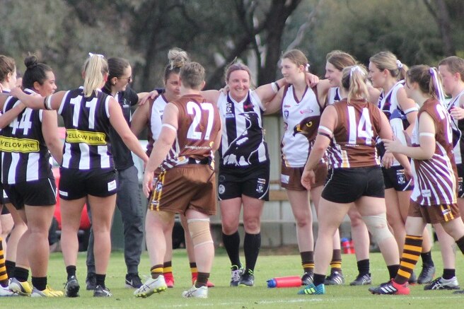 Women celebrate after a game of football in country Victoria.