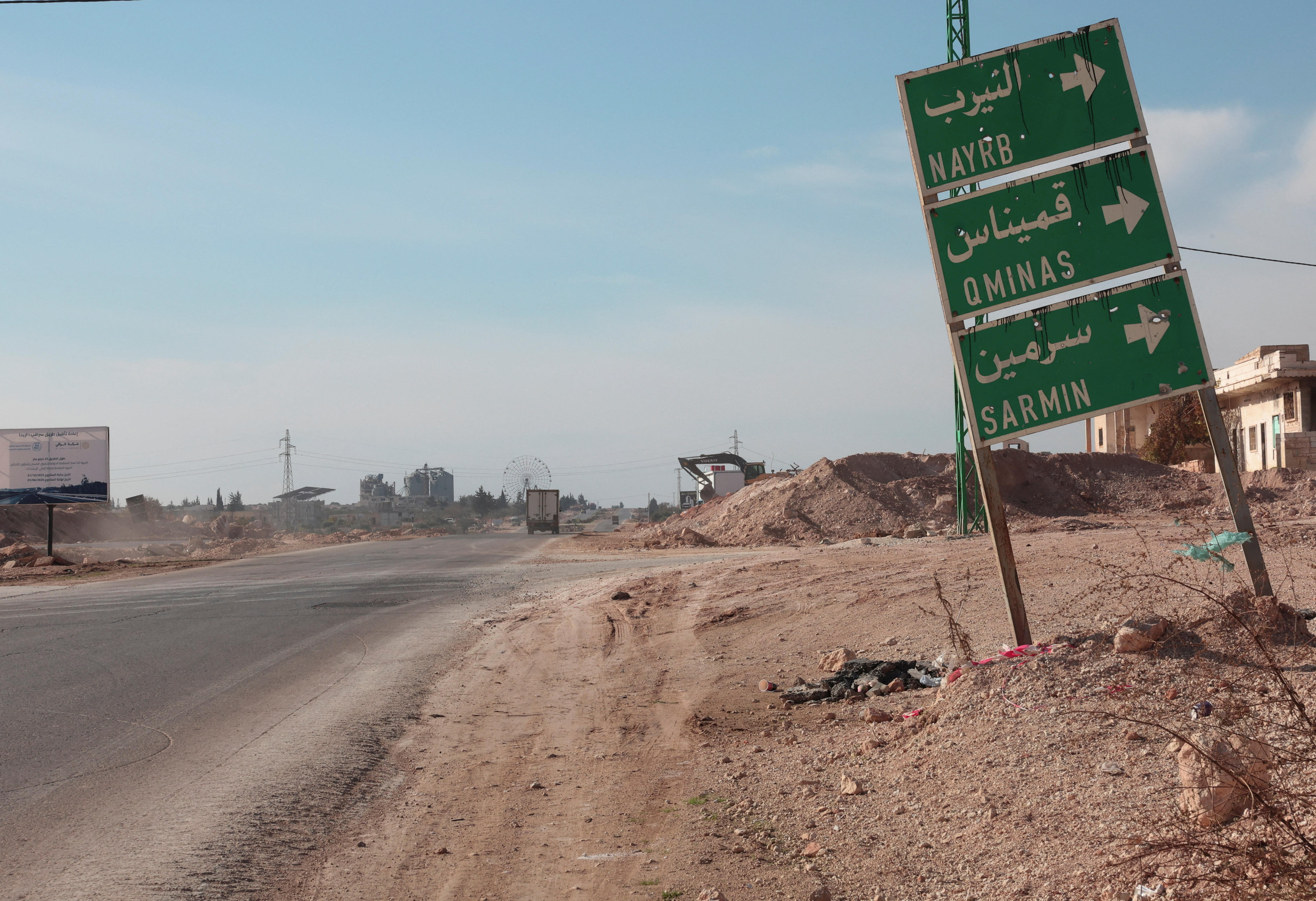 Uma placa de rua na beira de uma estrada empoeirada.