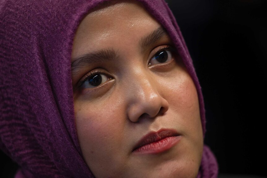 Yasmin Ullah looks at the camera wearing a purple head scarf.